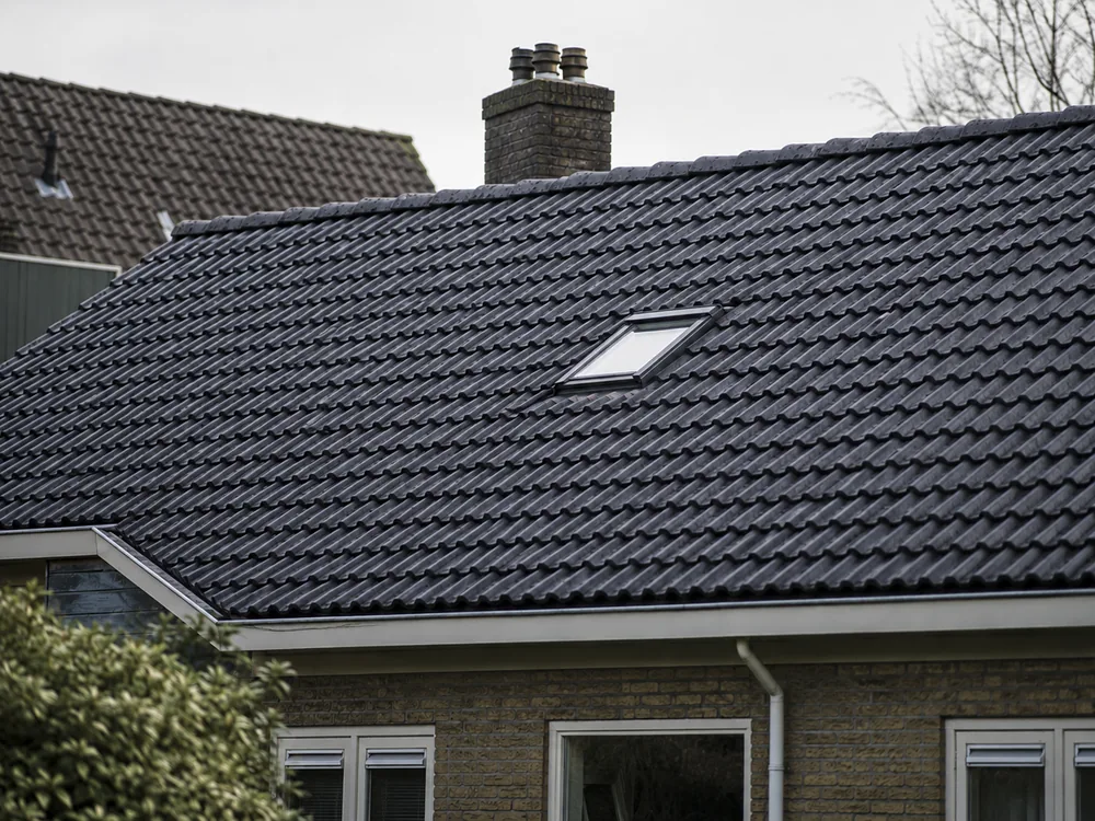 Dakreiniging: dak met mos en aanslag naast hetzelfde dak na de softwash-reiniging, na de reiniging