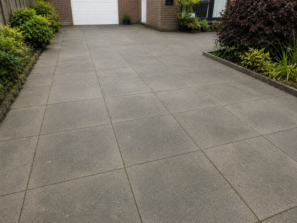 Terrasreiniging: tegels met groene aanslag naast dezelfde tegels na de powerwash-reiniging, na de reiniging